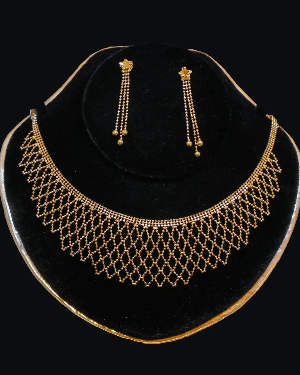 Goldenes Netz-Collier mit passenden Ohrhängern auf schwarzem Samt