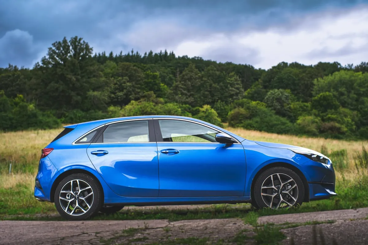 Blauer Kia Ceed von der Seite, am Feldrand geparkt