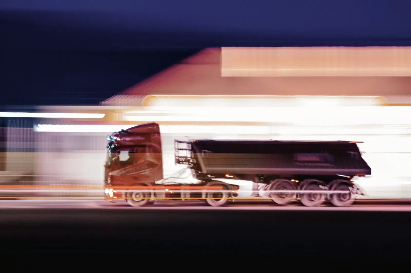 Lkw bei Nacht auf der Straße, mit langer Belichtung verwischte Lichter