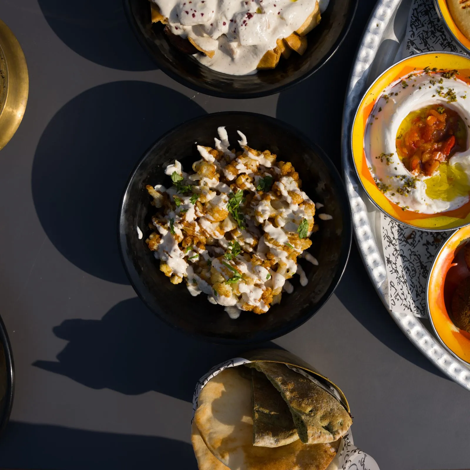 Mehrere Meze in kleinen Schalen auf einem dunklen Tisch