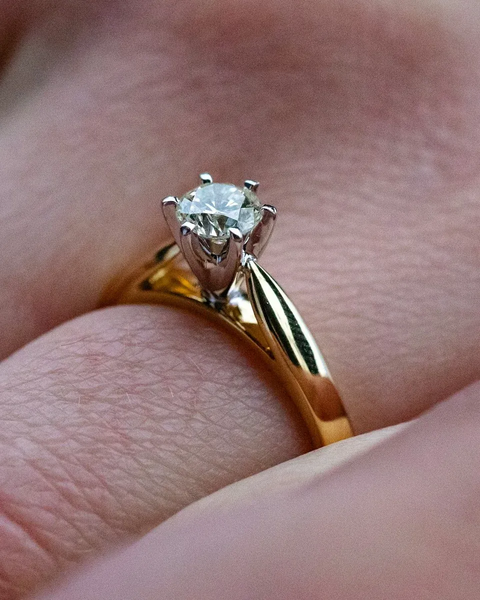 Verlobungsring aus Gelbgold mit einem Solitär an einer Hand